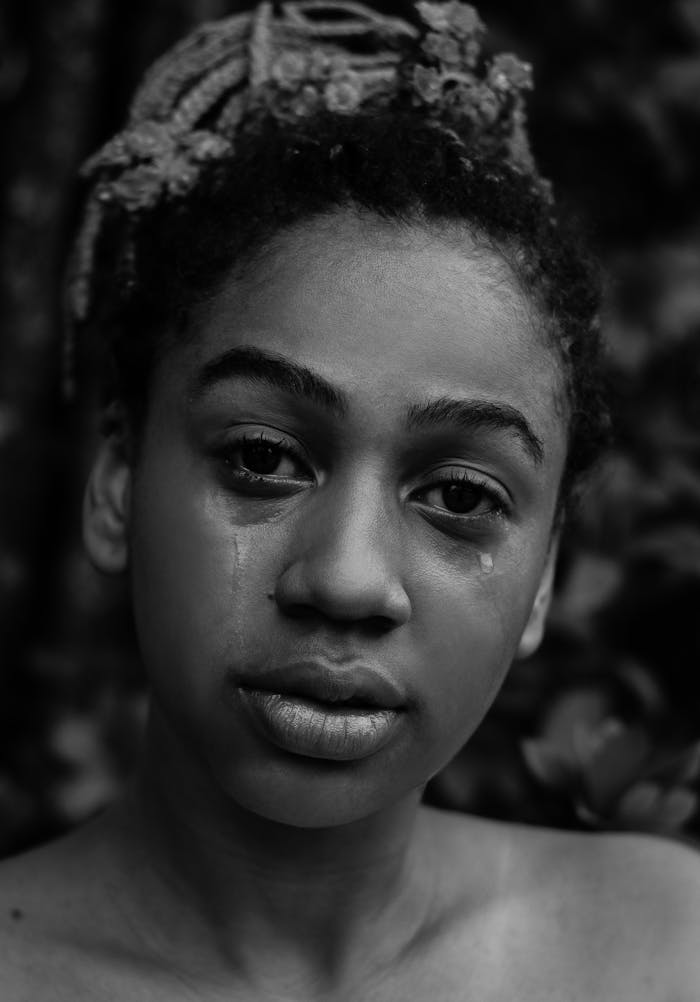 portfolio-01 A black and white portrait of a young woman expressing deep emotion with tears.